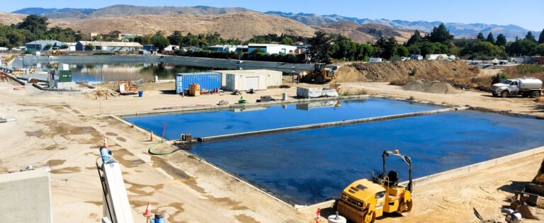 Sludge drying bed (foreground) and wastewater equlisation bassin (background), SLO WRRF