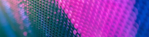 Abstract image of of what looks like metal mesh, mainly pink on blue and black.