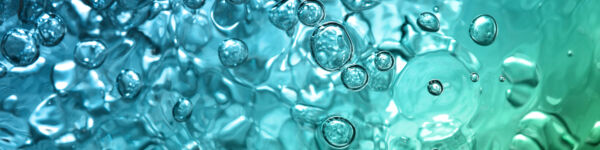 Image of bubbles in water. The water is mostly blue with tinges of green to the bottom right.