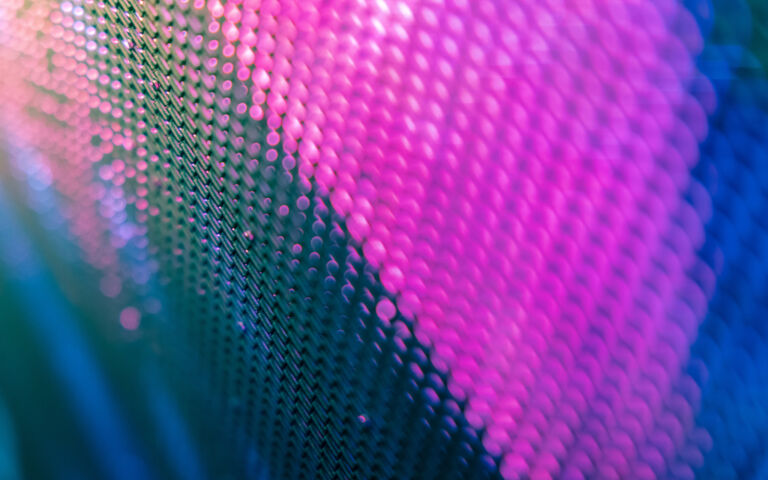 Abstract image of of what looks like metal mesh, mainly pink on blue and black.